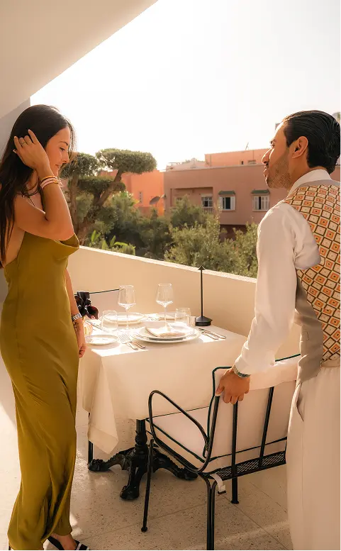 Serveur de la villa Chakamani, accompagnant une cliente à sa table, sur la terrasse du restaurant bistronomique, à la Villa Chakamani