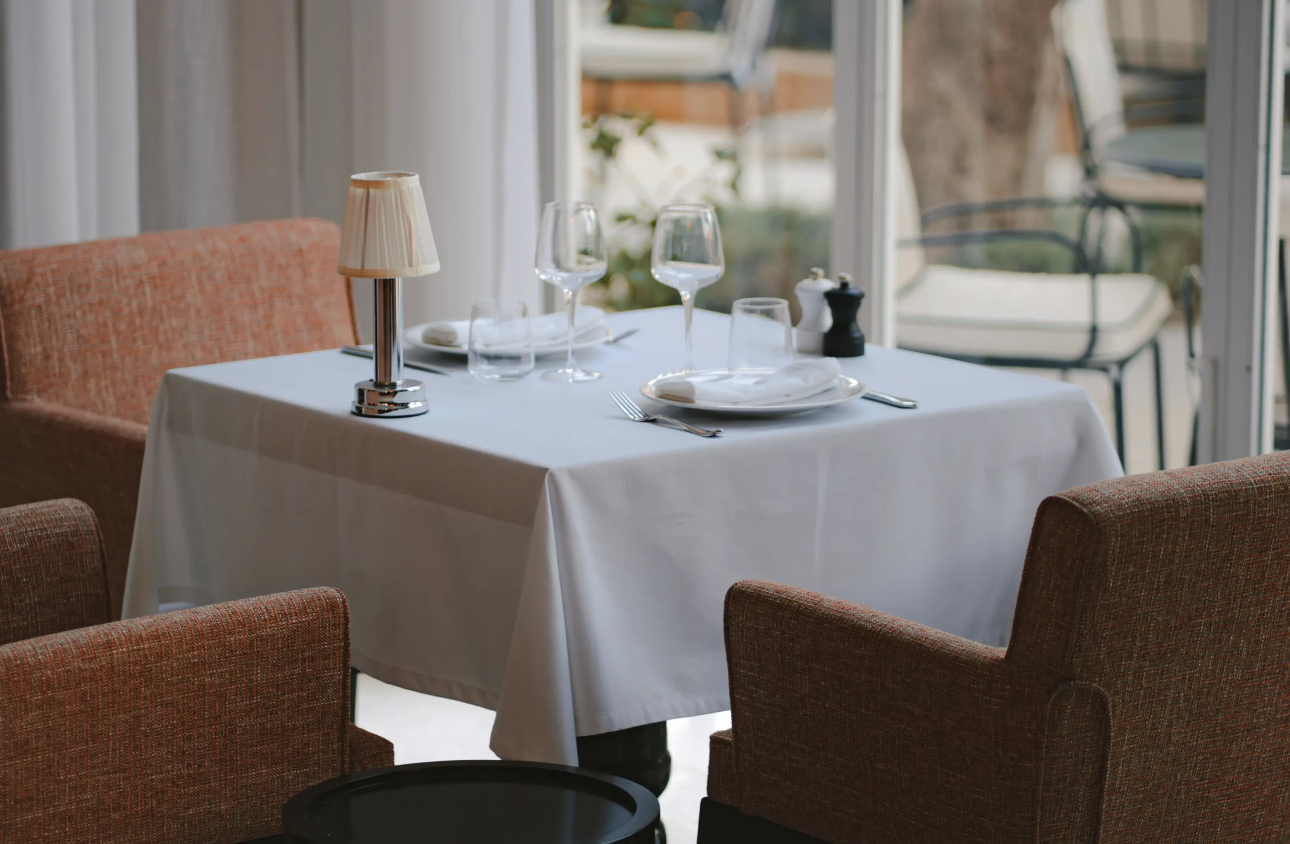 Table dressée au rez-de-chaussée de la villa Chakamani, devant une baie vitrée donnant sur la terrasse de la villa, située à Marrakech